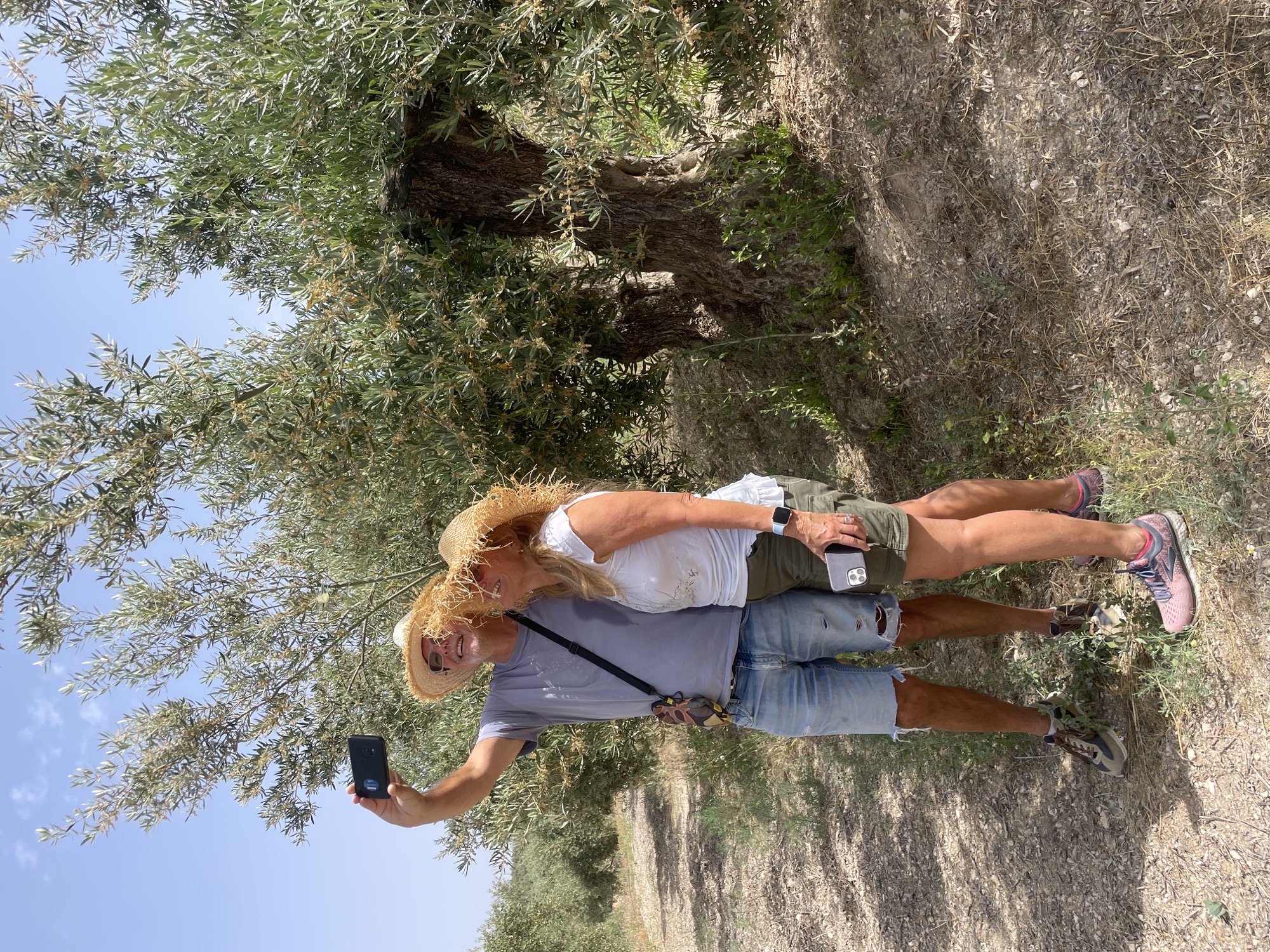 Visitors with their adopted olive tree in the grove
